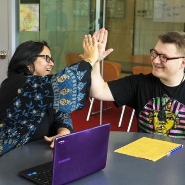 Student and DSS advisor high-fiving